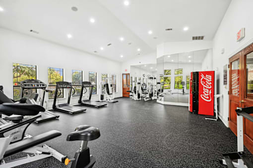 the gym with cardio machines and other exercise equipment at the belgard apartments