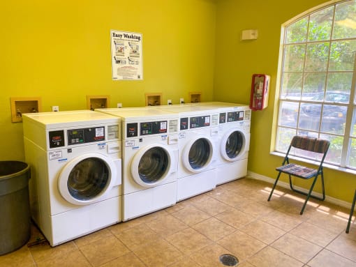 Laundry center with four side by side washing machines.