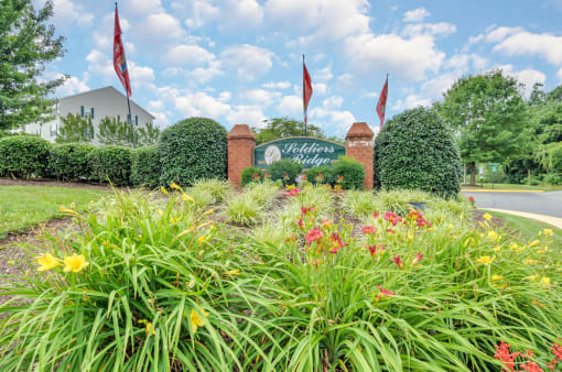 Community sign in the middle of a flower bed.