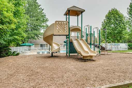 A playground with a slide and a wooden structure.