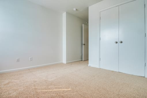 The bedroom has wall to wall carpet and double doors leading to closet.