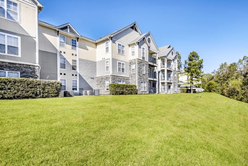 Building Exteriors and Hillside Grassy Courtyard with Treeline in the Distance