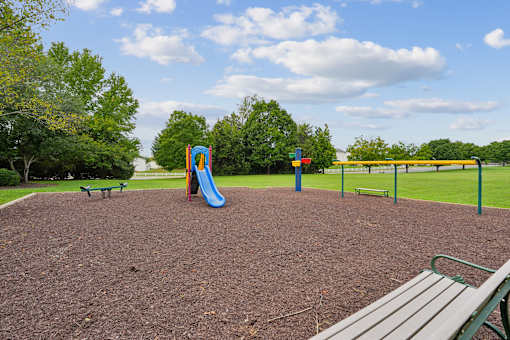 A playground with a slide and a seesaw.