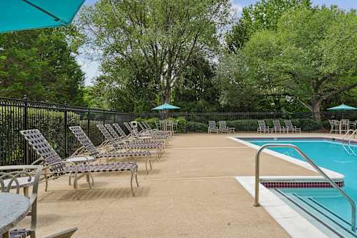 A pool area with chairs and a table.
