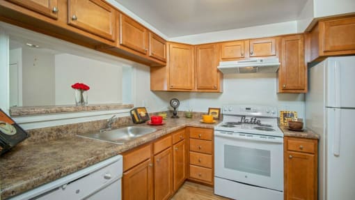 Kitchen with stove, dishwasher and refrigerator. Cabinets above all appliances and a breakfast bar