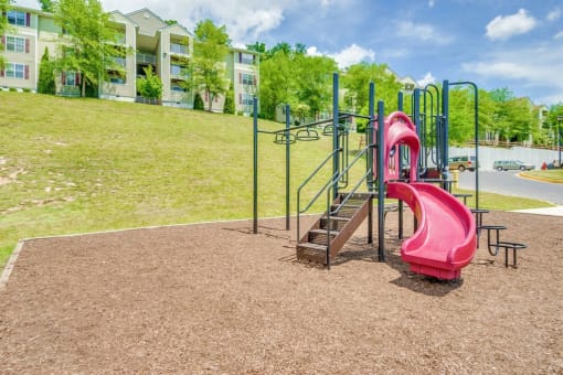 Playground For Children on wood chips and Apartment buildings in the background
