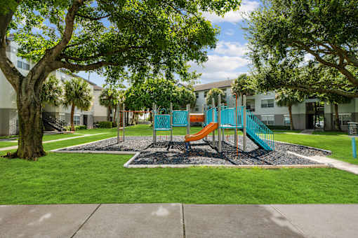 A playground with a slide and a tree.