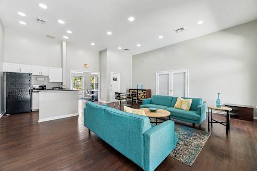 A modern kitchen with a blue couch and a wooden floor.