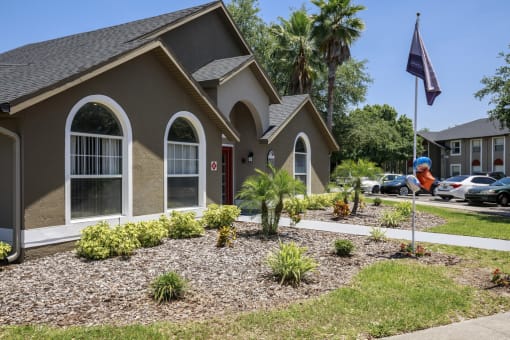 a house with a landscaped front yard and a flag