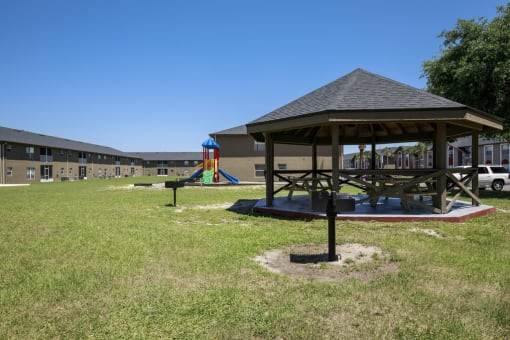 a gazebo with a playground in front of a building
