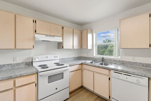 a kitchen with white appliances and granite counter tops and wooden cabinets