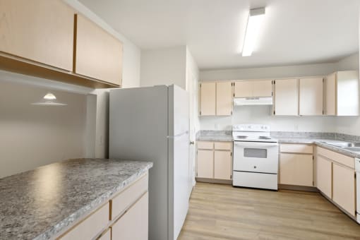 a kitchen with white appliances and granite counter tops