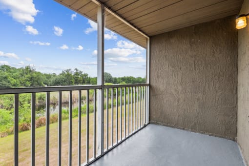 a balcony with a view of a field and trees