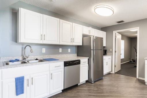a kitchen with white cabinets and a stainless steel refrigerator