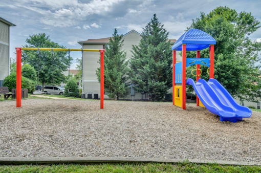 Playground on wood clips surrounded by building exteriors and trees