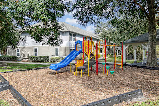 A playground with a blue slide and red and yellow play structures.