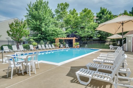Swimming pool with sundeck, umbrellas and lounge chairs