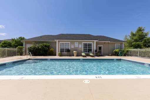 Swimming Pool with Lounge Seating on Sun Deck in Front of Leasing Office