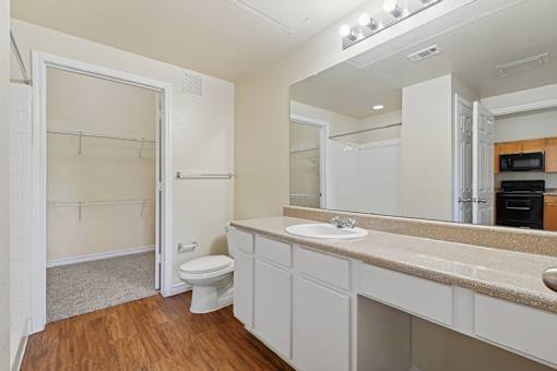 A white bathroom with a toilet, sink, and mirror.