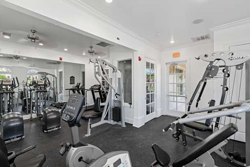 A gym with a variety of equipment including treadmills, weights, and exercise machines.