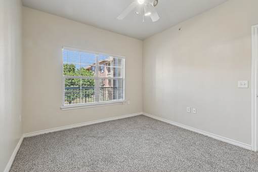 A room with a window and a ceiling fan.