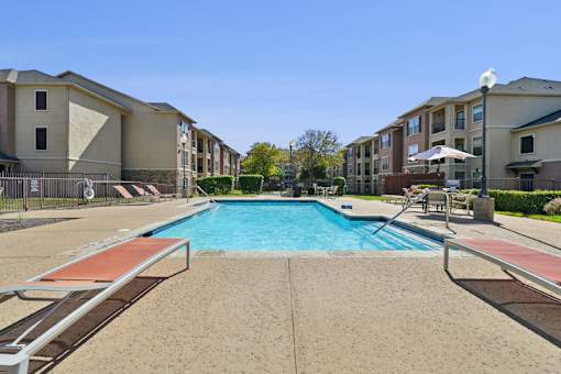 A swimming pool surrounded by apartment buildings.
