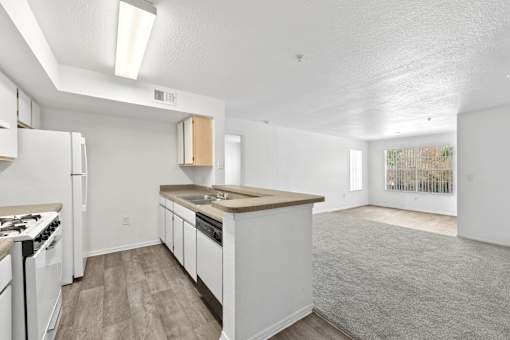 A kitchen with white appliances and wooden cabinets.