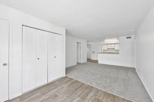 A room with white walls and a grey carpet.