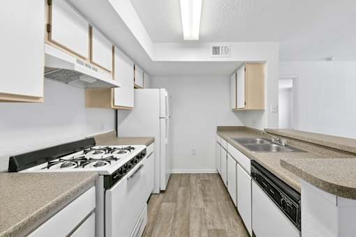 A kitchen with white cabinets and a black stove top.