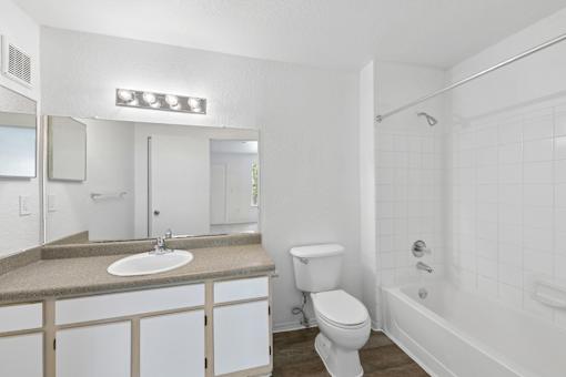 A white bathroom with a sink, toilet, and bathtub.