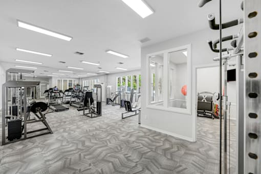 a spacious fitness center with cardio machines and weights