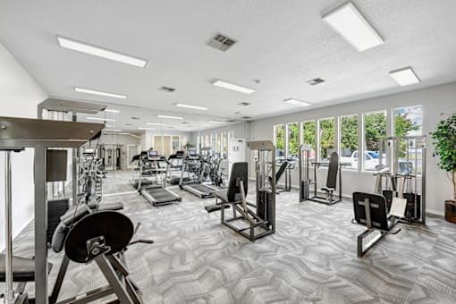 a spacious fitness center with cardio machines and other exercise equipment