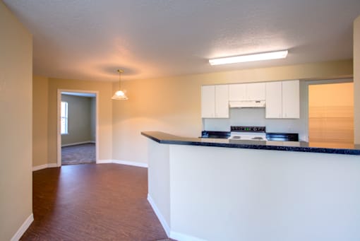a kitchen with white cabinets and a black counter top