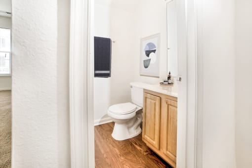 a bathroom with white walls and wood floors