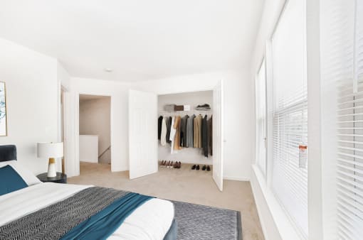 a bedroom with a large window and a bed with a blue blanket