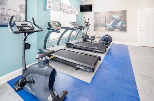 a home gym with two treadmills and two elliptical machines