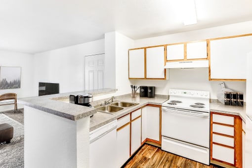 Model Kitchen with White Appliances, Grey Counters and White Cabinets with Wood Accents