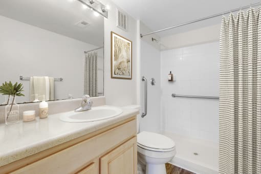a bathroom with a white sink and toilet next to a white bathtub with a shower curtain