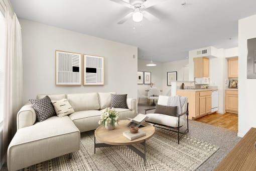 a living room with a white couch and a coffee table with a vase of flowers on