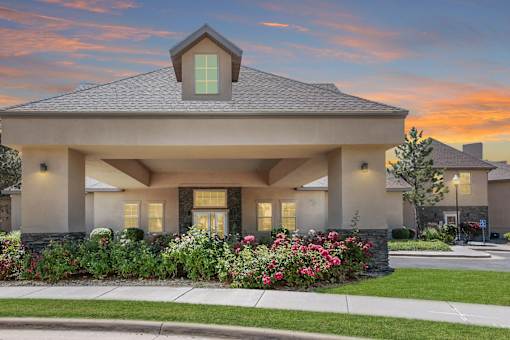 Community building with landscaped grounds at dusk at Rose Cove Homes Apartments, Farmington, 84025