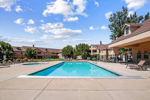 Outdoor pool with surrounding patio and seating at Rose Cove Homes Apartments, Utah