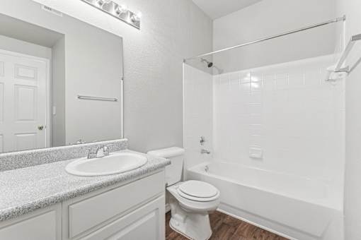 A white bathroom with a sink, toilet, and bathtub.