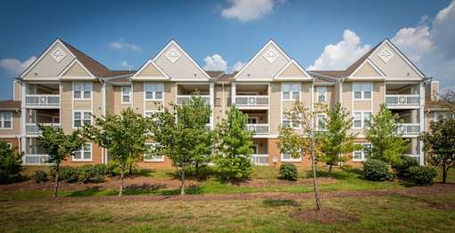 an apartment complex with trees in front of it