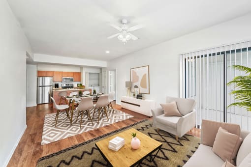 virtually staged living and dining room with hardwood-style flooring, ceiling fan, and sliding-door patio access