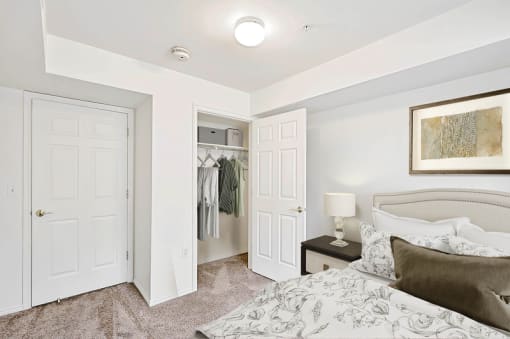 Bedroom with walk-in closet and neutral bedding at Rose Cove Homes Apartments, Farmington, UT