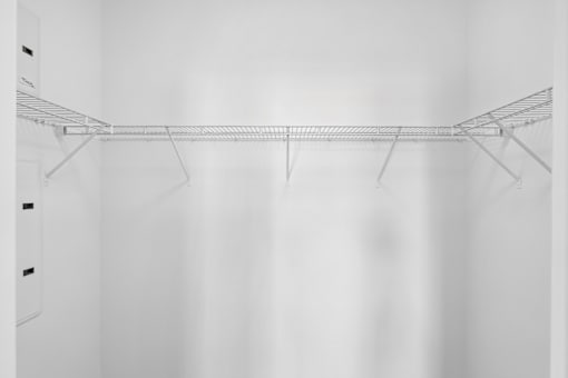 A white closet with a wire shelf.