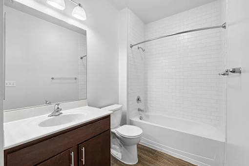 A white bathroom with a toilet, sink, and bathtub.