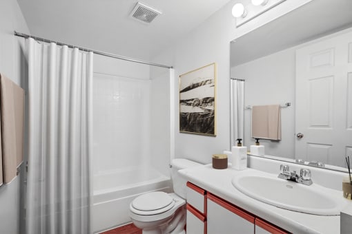 Virtually staged bathroom with shower curtain, wall art, white sink and countertop and shower