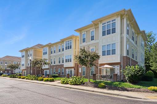 A row of townhouses with a clear blue sky above them.