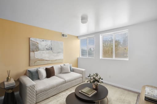 Virtually staged livingroom with couch, wall art, accent rug, side table, coffee table, tv stand, two windows and tan accent wall